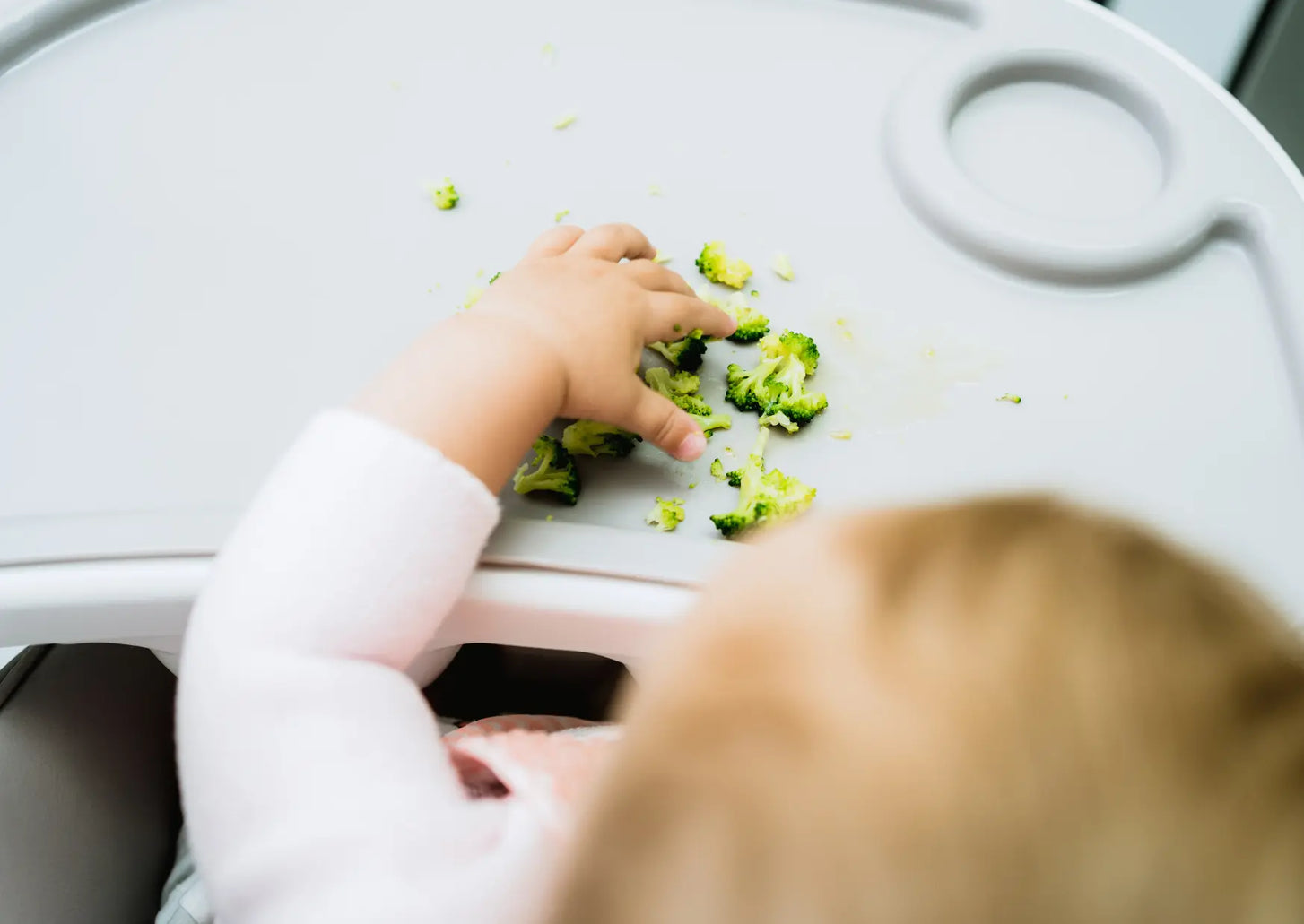 Baby isst selbstständig Stückchen Obst