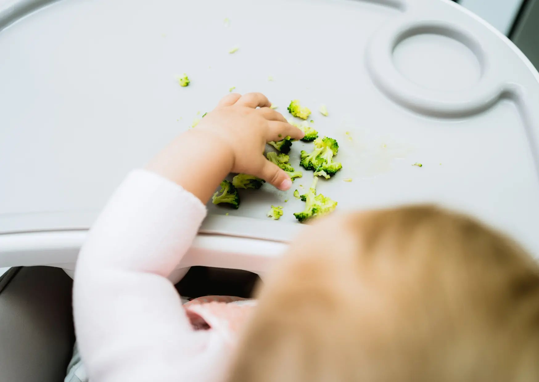 Baby isst selbstständig Stückchen Obst