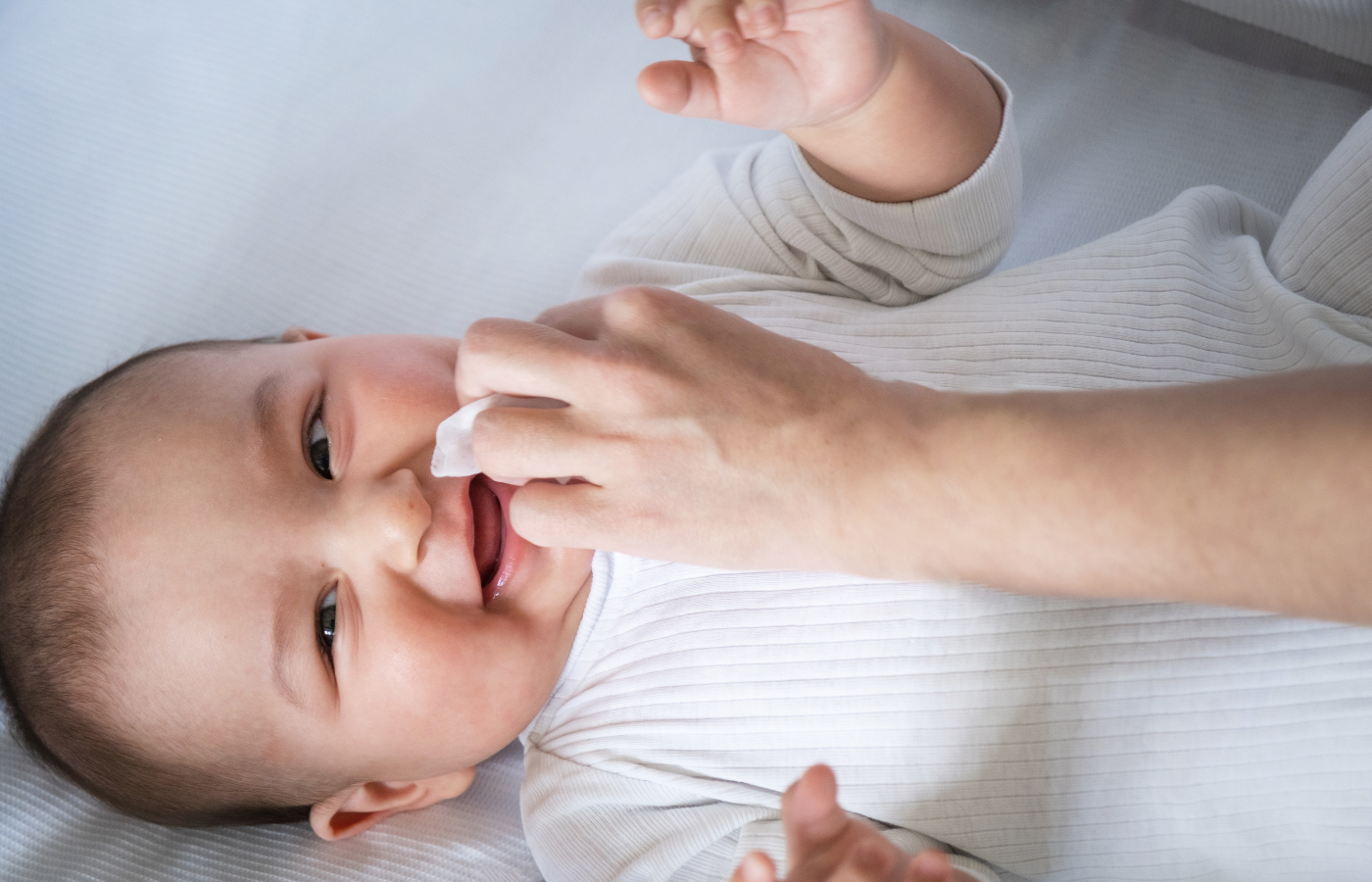 Ein Elternteil reinigt die Nase eines Babys mit einem Nasensauger