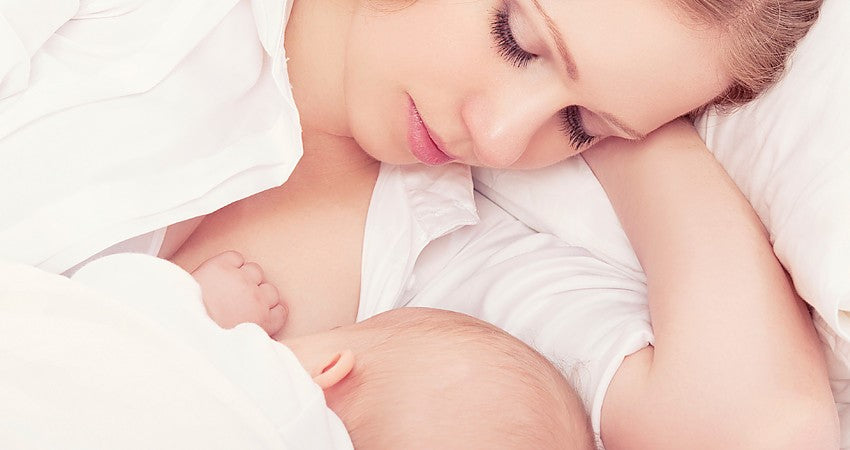 Ein Elternteil stillt das Baby
