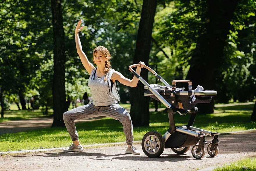Ein Elternteil macht eine Kniebeuge mit Baby in der Nähe