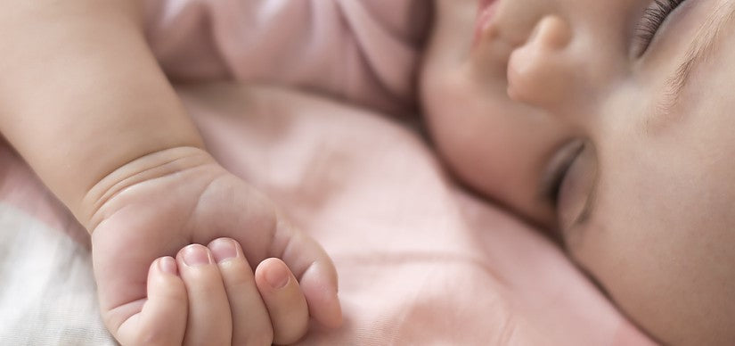 Ein Elternteil hält das Baby nach dem Füttern aufrecht